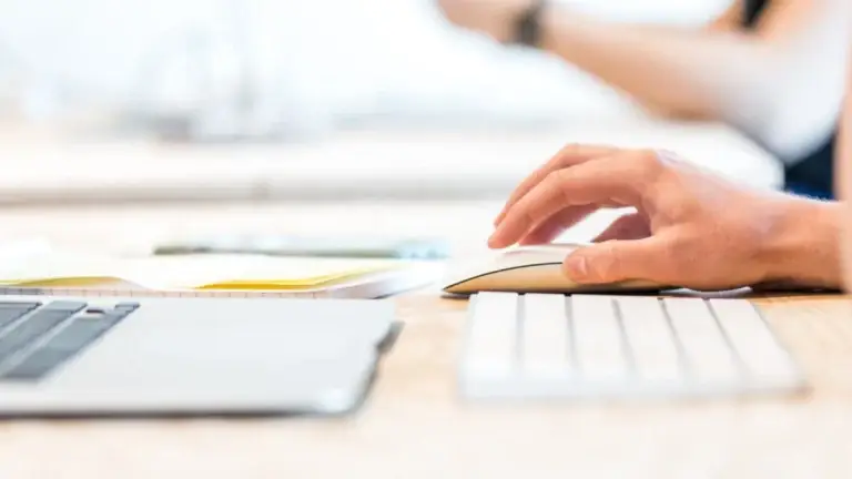 Image of someone with their hand on a computer mouse