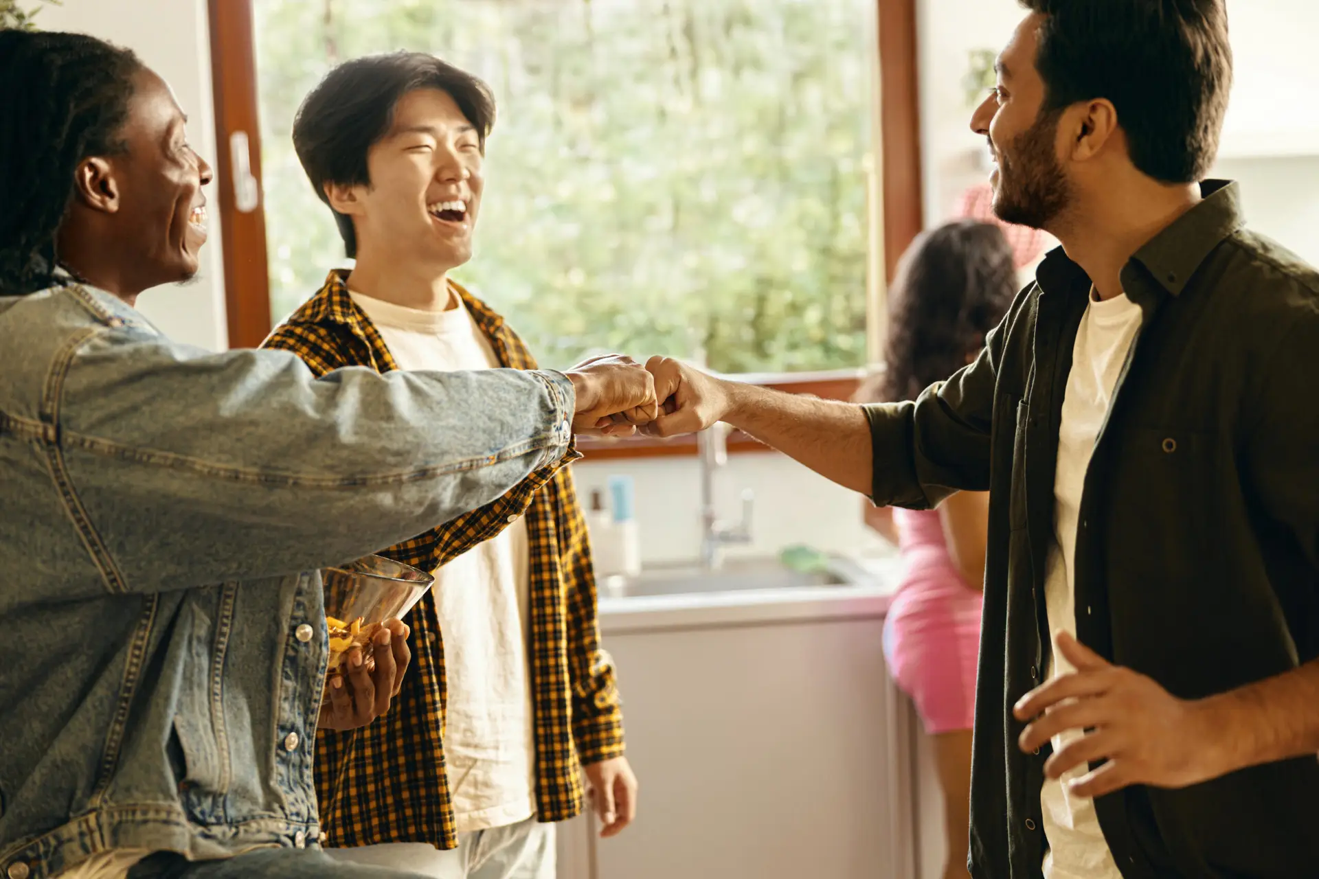 Happy young friends giving fist bump greeting each other