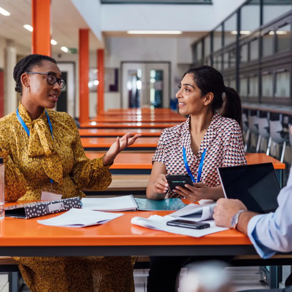 SylogistGov Image of three business people discussing at an orange table