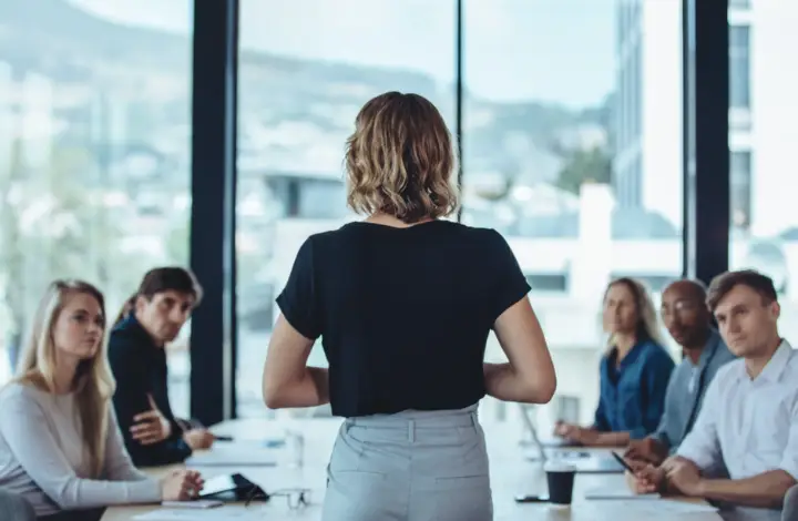 Victim Services Suite: a women speaking to people at the head of a long table