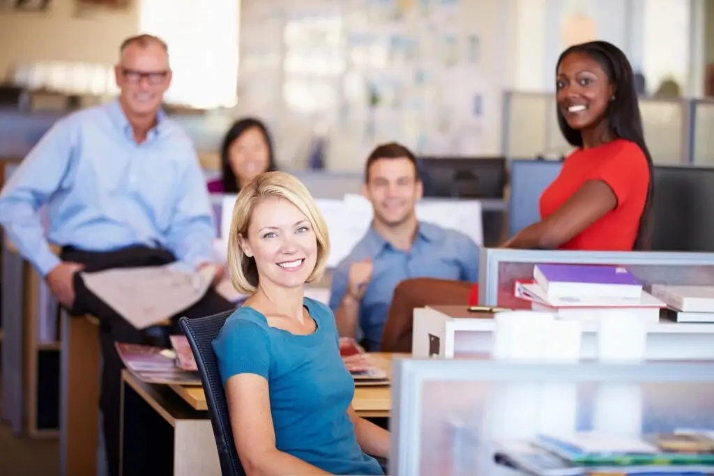 Image of five smiling people in an office space