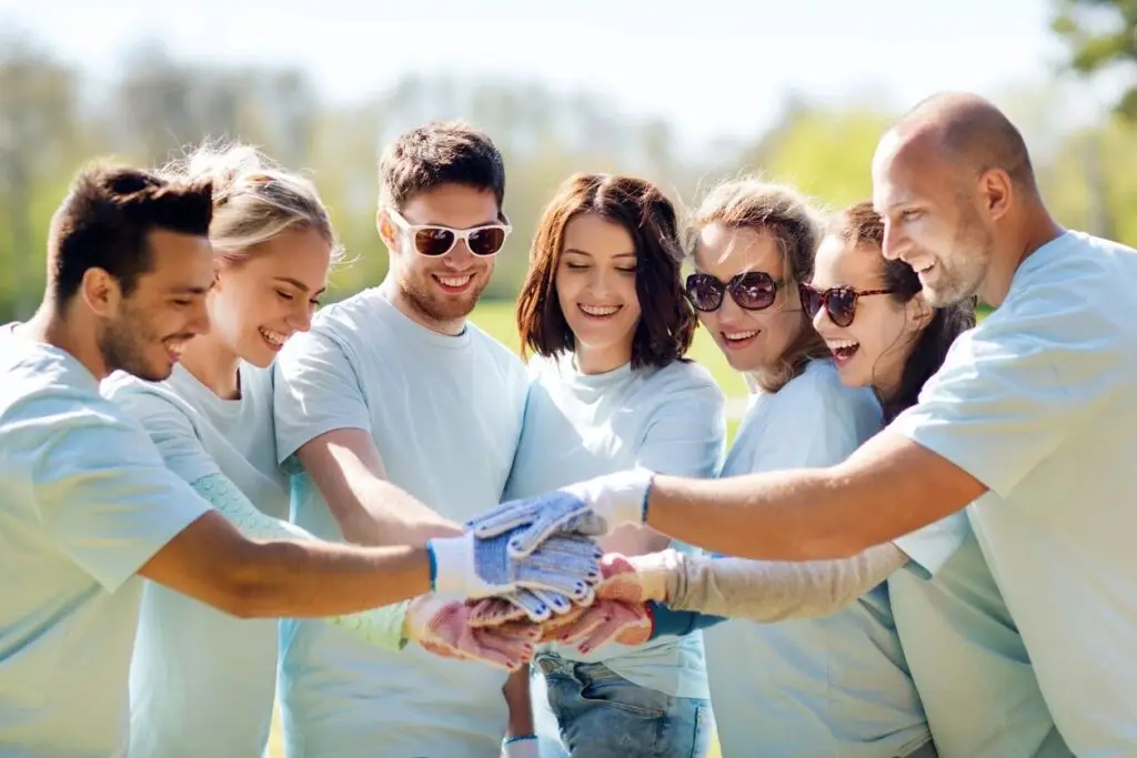 Image of seven people putting their gloved hands together