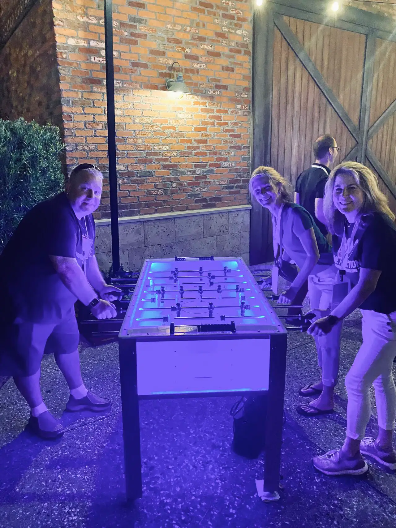 three people playing foosball