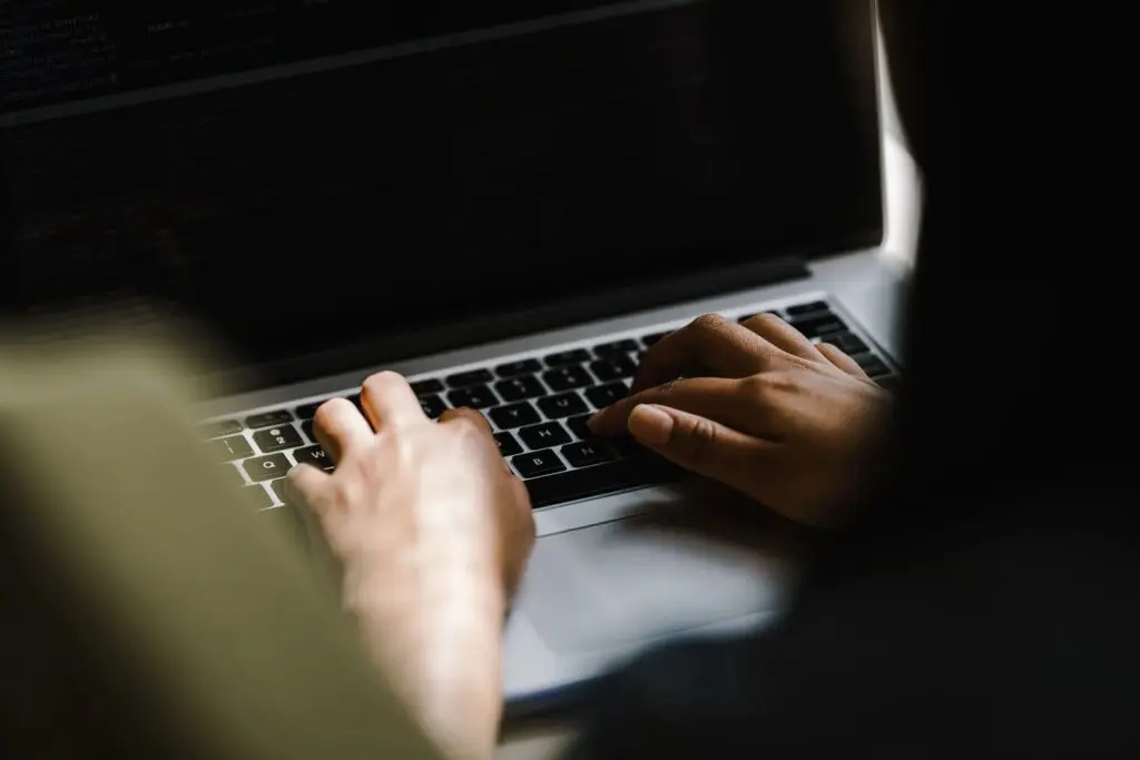 zoomed in image of a woman typing on her laptop