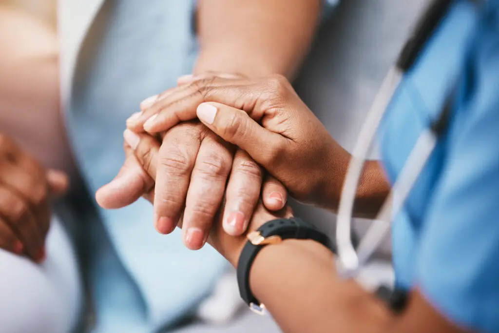 Nurse holding hands with patient