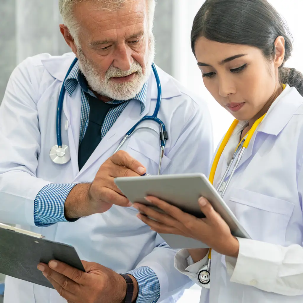 Two doctors discussing a case looking at a tablet