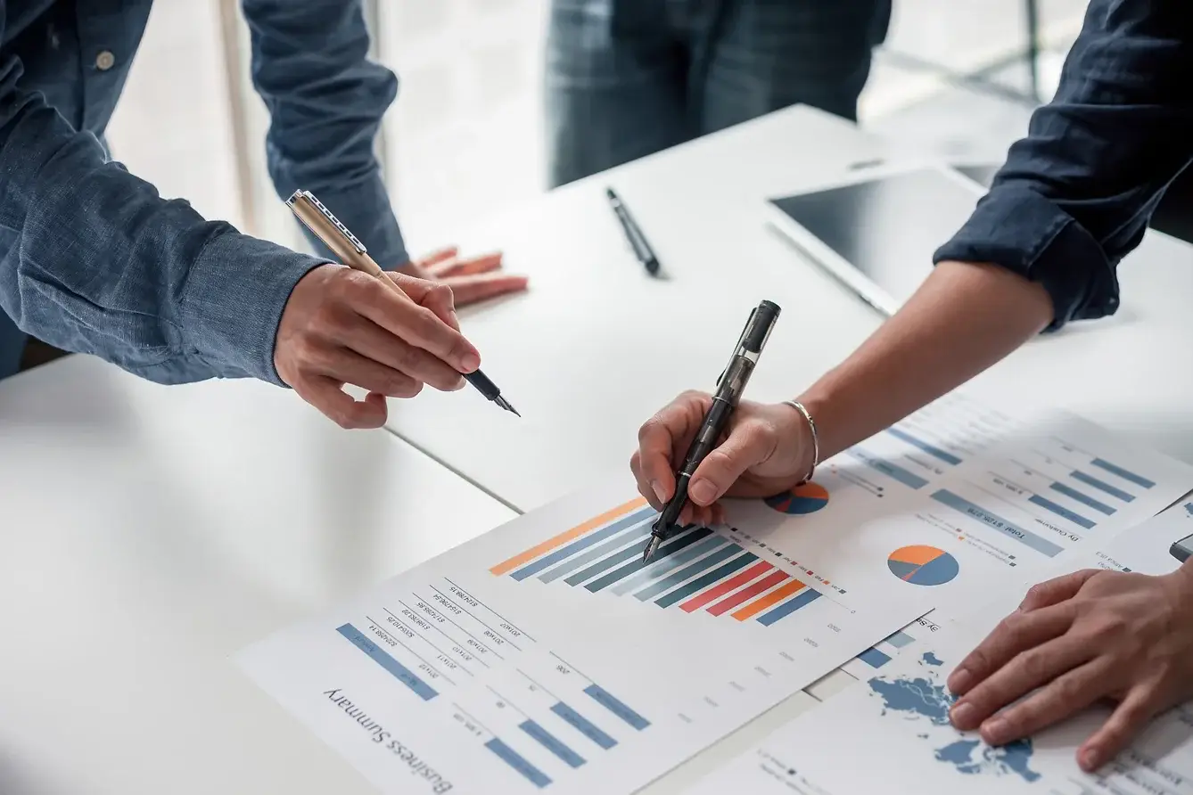 image of two people writing on a bar chart